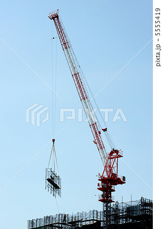足場を吊り上げるタワークレーンの写真素材