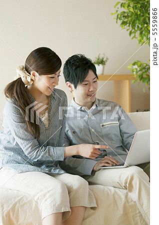 ソファーでノートパソコンを見るカップル 5559866