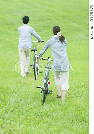 草原で自転車を押すカップルの後姿 草原で自転車を押すカップルの後姿 5559876