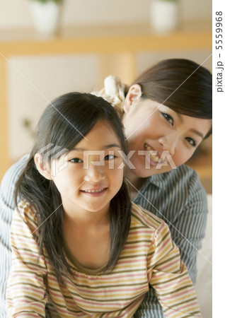 娘を抱き微笑む母親 娘を抱き微笑む母親 5559968