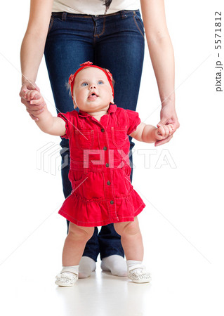 little baby girl doing first step with help of mother 5571812