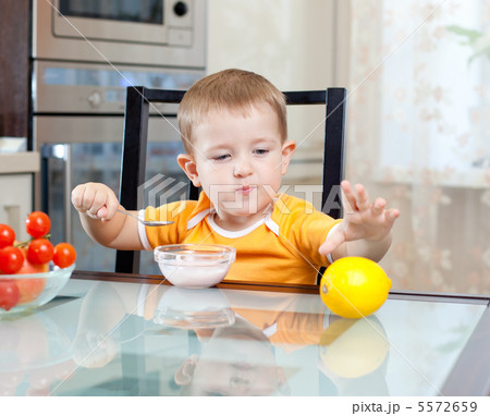 cute little boy eating healthy food at kitchen cute little boy eating healthy food at kitchen 5572659