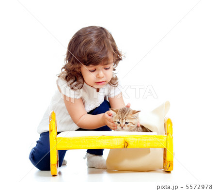 curly child girl playing with kitten as mother with baby 5572978
