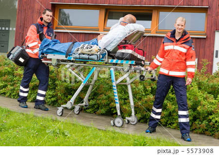 Paramedics with patient on stretcher ambulance aid 5573908