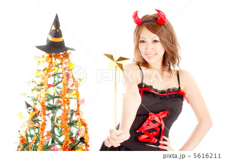 可愛らしく杖を振るハロウィンの女悪魔の写真素材