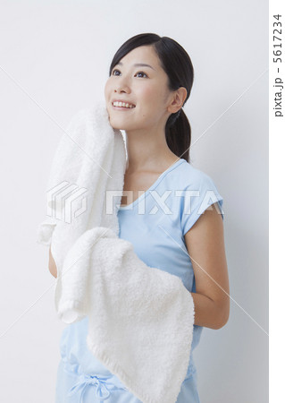 タオルで汗を拭くスポーツウェアの女性の写真素材