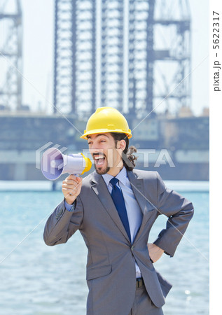 Man wearing helmet speaks with megaphone Man wearing helmet speaks with megaphone 5622317