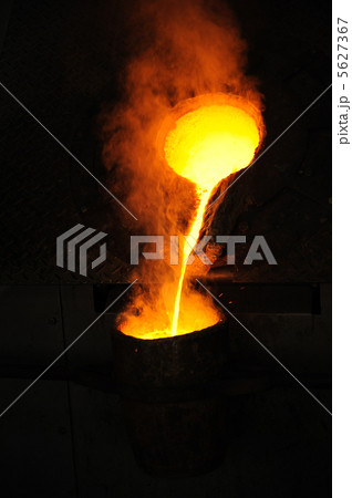 Foundry - molten metal poured from ladle for casting 5627367