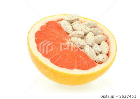 Close up of red grapefruit and pills isolated - vitamin concept Close up of red grapefruit and pills isolated - vitamin concept 5627453