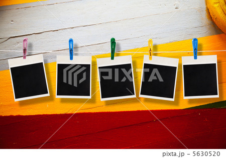 Blank picture frame hanging on clothesline on wood background Blank picture frame hanging on clothesline on wood background 5630520