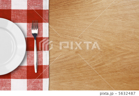 white plate and fork on wooden table with red checked tablecloth white plate and fork on wooden table with red checked tablecloth 5632487