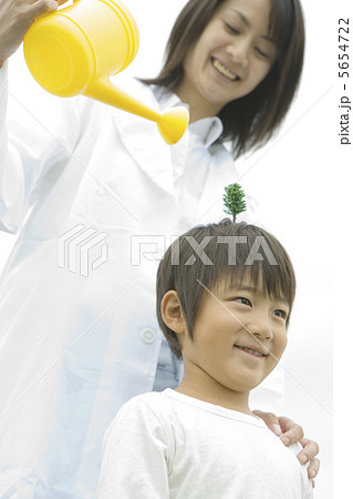 少年の頭に生えた木に水を注ぐ女性 少年の頭に生えた木に水を注ぐ女性 5654722