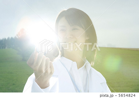 光る電球を見つめる白衣の女性 光る電球を見つめる白衣の女性 5654824