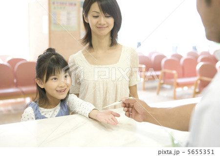 病院の受付で体温計を受け取る少女 5655351