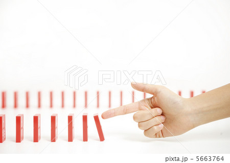 並んだドミノを倒そうとする手 5663764