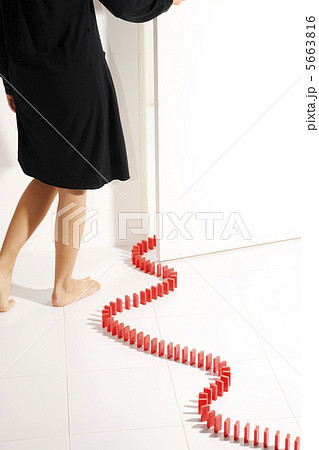 ドミノの列が続くドアを開けようとする女性の後姿 ドミノの列が続くドアを開けようとする女性の後姿 5663816