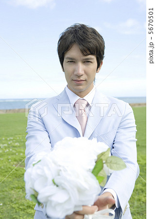 花束を渡す男性の写真素材
