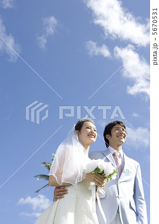 青空の下に立つ新郎新婦 5670531