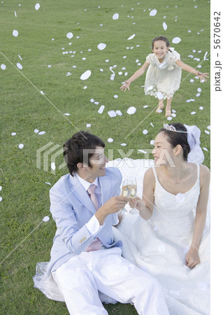 野原に座り乾杯する新郎新婦 5670642
