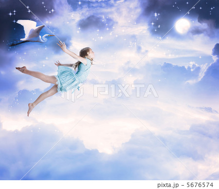 夜空を飛ぶ女の子の写真素材