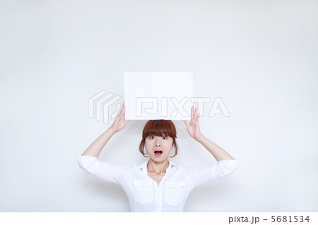 メッセージボードを頭に載せる若い女性 5681534