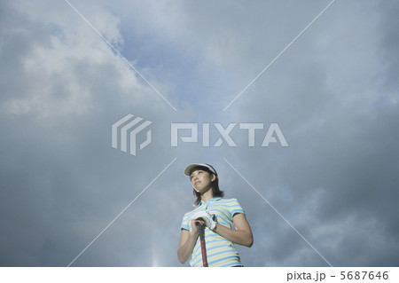 大空の下で遠くを見つめる20代女性 5687646