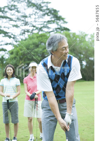 ゴルフをする父と後ろで見守る母と娘 5687655