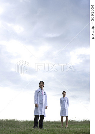 野原に立つ男女二人の医療関係者 5691054
