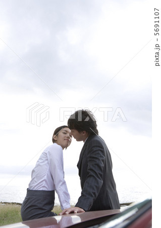車の横でキスをするカップル 5691107