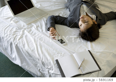 ベッドでくつろぐビジネスウーマン ベッドでくつろぐビジネスウーマン 5691169