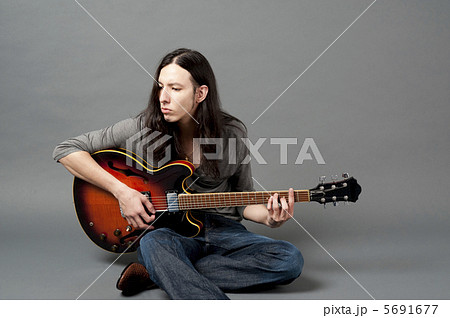 ギターを弾く若い男性の写真素材