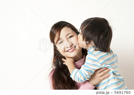 子供にキスされる母親の写真素材