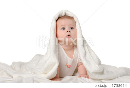 The baby under a towel. Age of 8 months. It is isolated on a whi 5738634