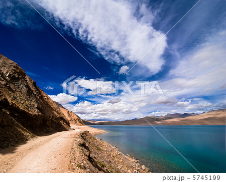 Road going along high mountain lake under blue cloudy sky. Himal 5745199