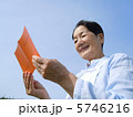 年金手帳に見入るシニア女性　横　アップ 5746216