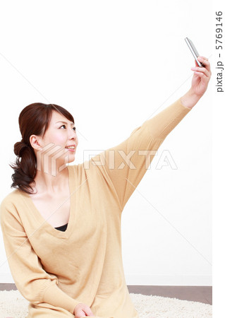 リビングで写メする女性 5769146