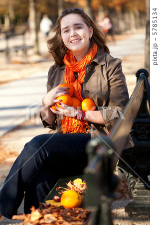 Beautiful young woman with oranges in park at fall Beautiful young woman with oranges in park at fall 5785134