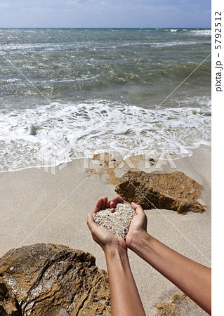 Mellow heart shaping female hands above beach 5792512