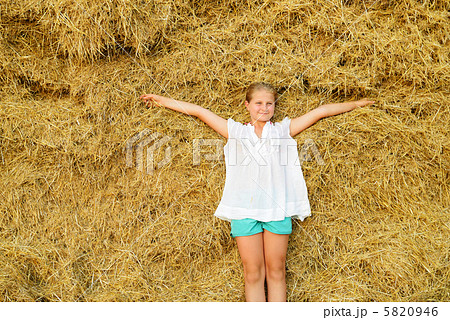 Girl on the background of the large stack of hay Girl on the background of the large stack of hay 5820946