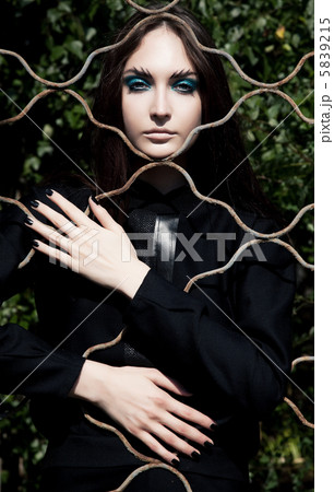 Emotions. Pretty woman posing in cage outdoors 5839215