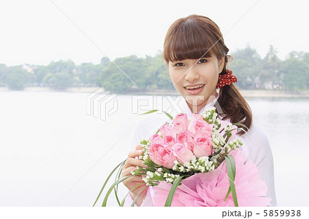 花束を持った笑顔のベトナム人女性の写真素材