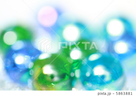 背景素材 キラキラ光る青と緑のビー玉の写真素材