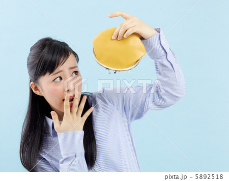 財布を持って悩む女の子・ブルーバック 5892518