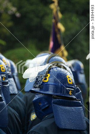 雨に立つ警視庁機動隊警察官の写真素材