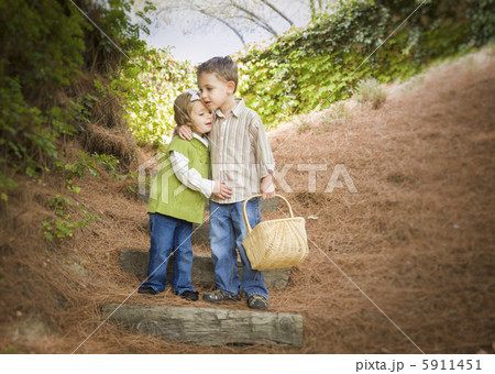 Two Children with Basket Hugging Outside on Steps 5911451
