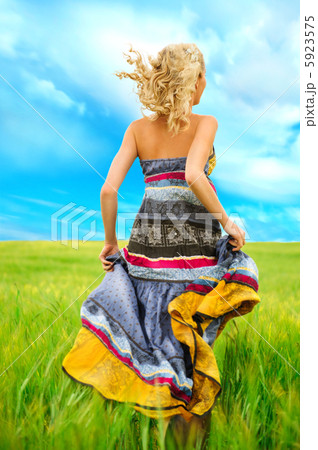 Portrait of romantic woman running across field 5923575