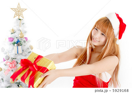 クリスマスプレゼントを手渡そうとしている可愛い女性のサンタさんの写真素材 クリスマスプレゼントを手渡そうとしている可愛い女性のサンタさんの写真素材