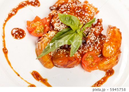 portion of sesame chicken served on a white plate portion of sesame chicken served on a white plate 5945758