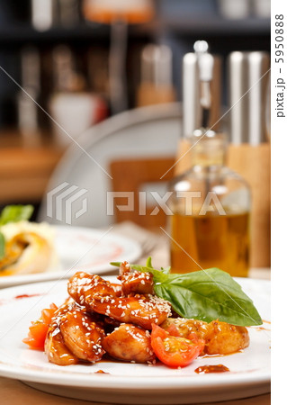 portion of sesame chicken served on a white plate 5950888
