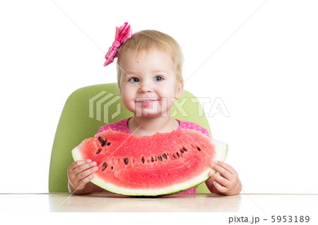Little girl eating watermelon at table Little girl eating watermelon at table 5953189